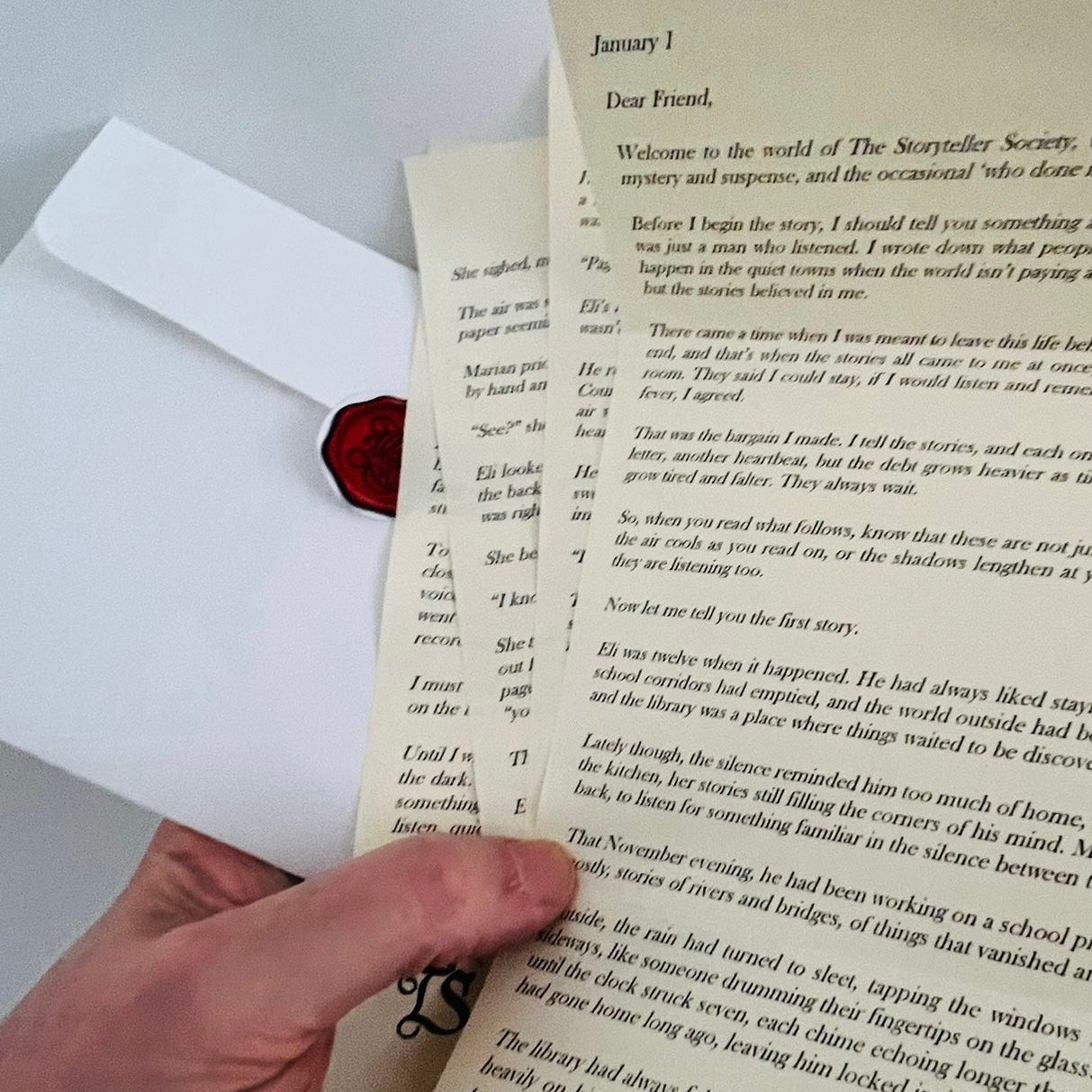 Hand holding a letter with text on a white background